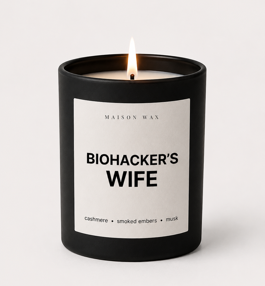 Maison Wax 'Biohacker's Wife' candle, lit, with cashmere, smoked embers, and musk scent notes.