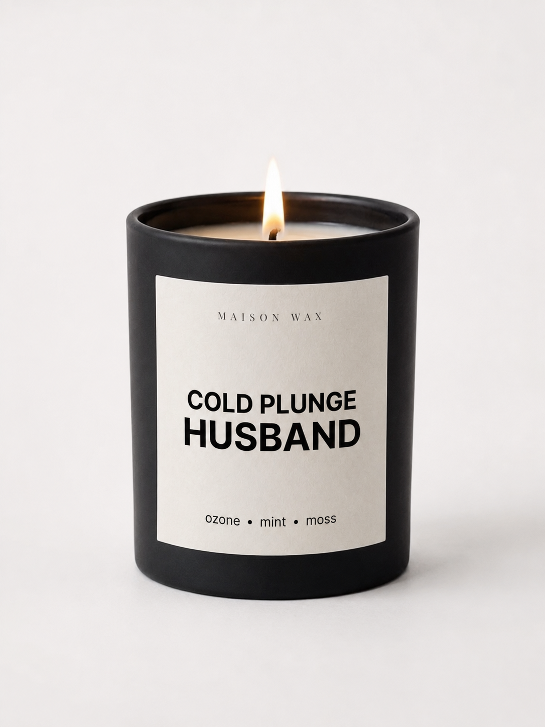 Maison Wax 'Cold Plunge Husband' candle, lit, with ozone, mint, and moss scent notes.