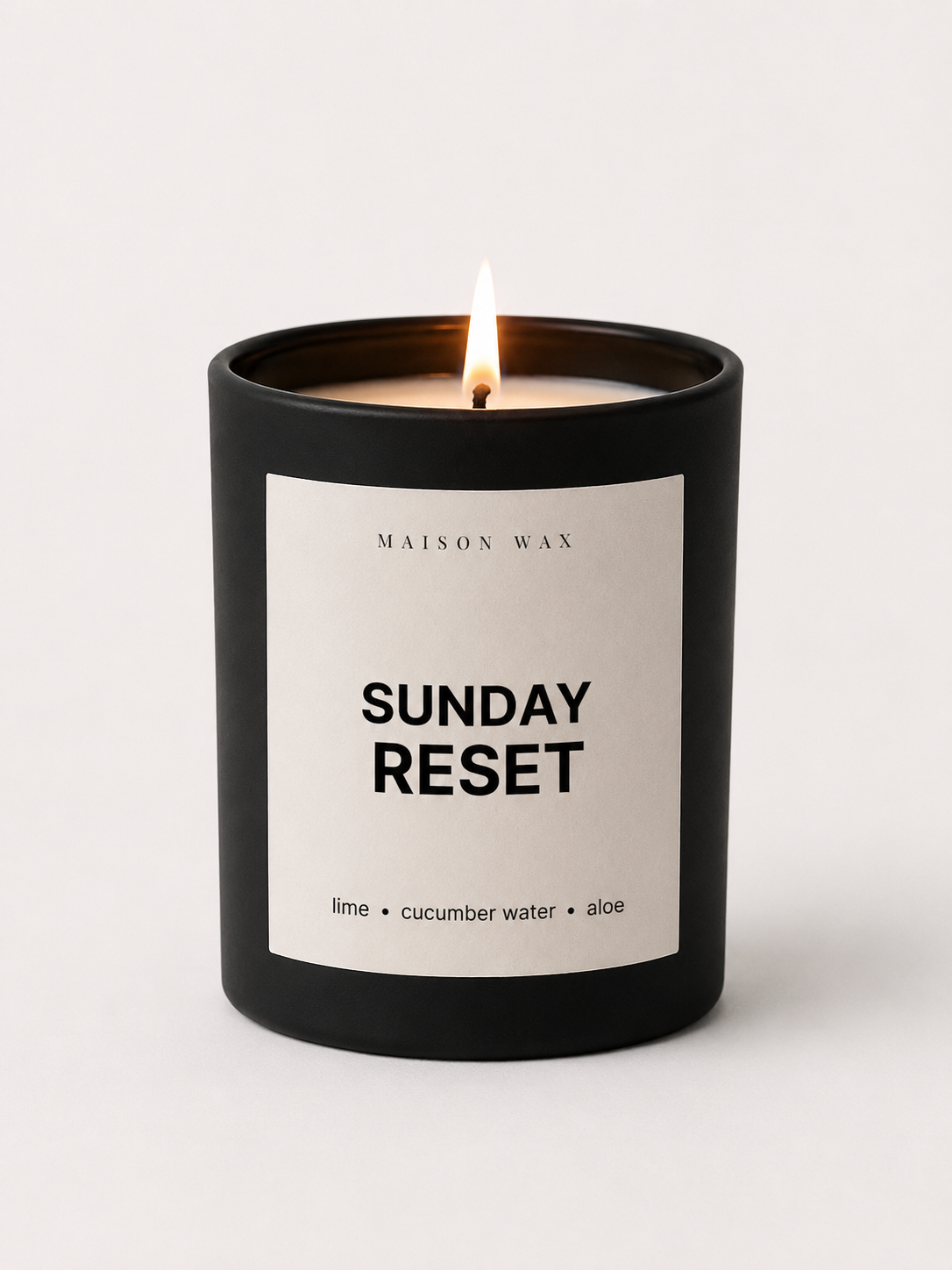 Maison Wax 'Sunday Reset' candle, lit, with lime, cucumber water, and aloe scent notes.